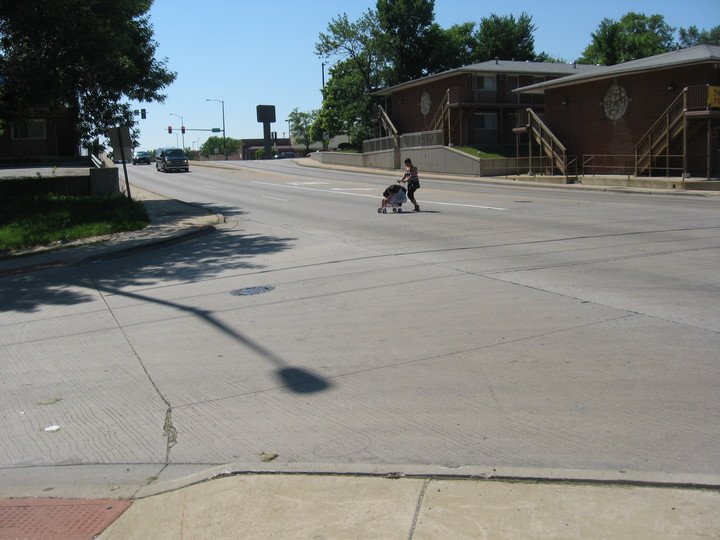 Person crossing wide street with stroller